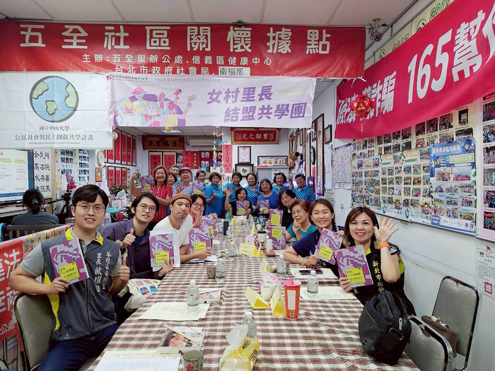 與會者齊拿手冊合影圖片